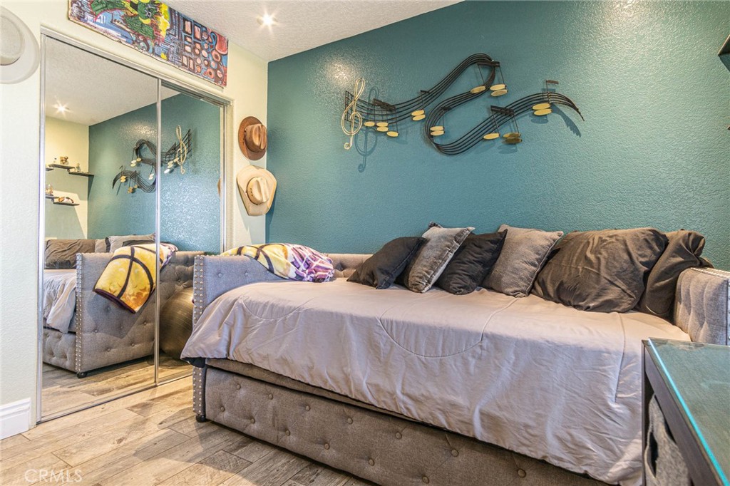 9735 Elsinore Road Oak Hills, CA 92344 - Photo 17 of 64 a bedroom with a bed couch and painting on the wall