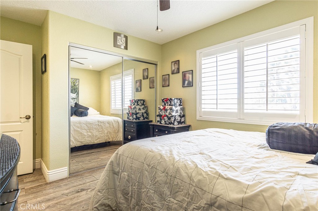 9735 Elsinore Road Oak Hills, CA 92344 - Photo 20 of 64 a bedroom with a bed and a large mirror