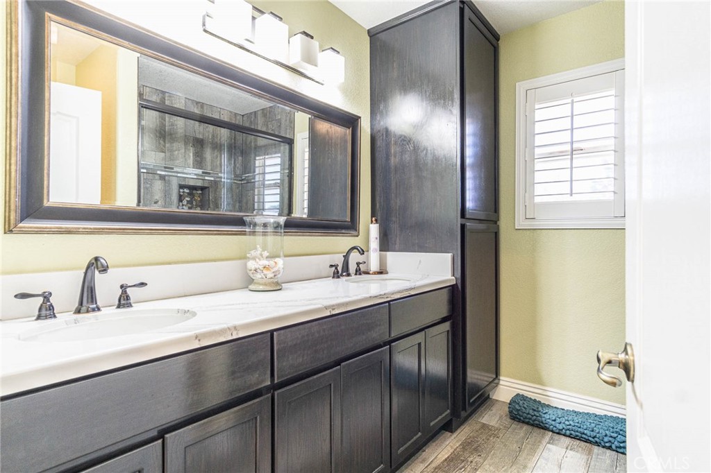 9735 Elsinore Road Oak Hills, CA 92344 - Photo 25 of 64 a bathroom with a double vanity sink and a mirror