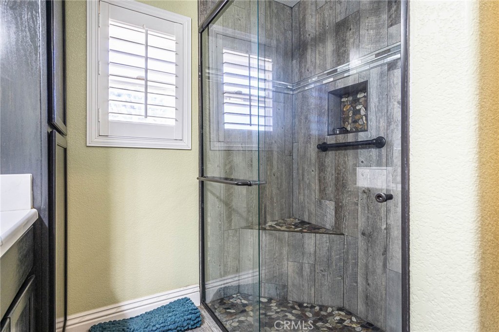 9735 Elsinore Road Oak Hills, CA 92344 - Photo 26 of 64 a bathroom with a glass shower door