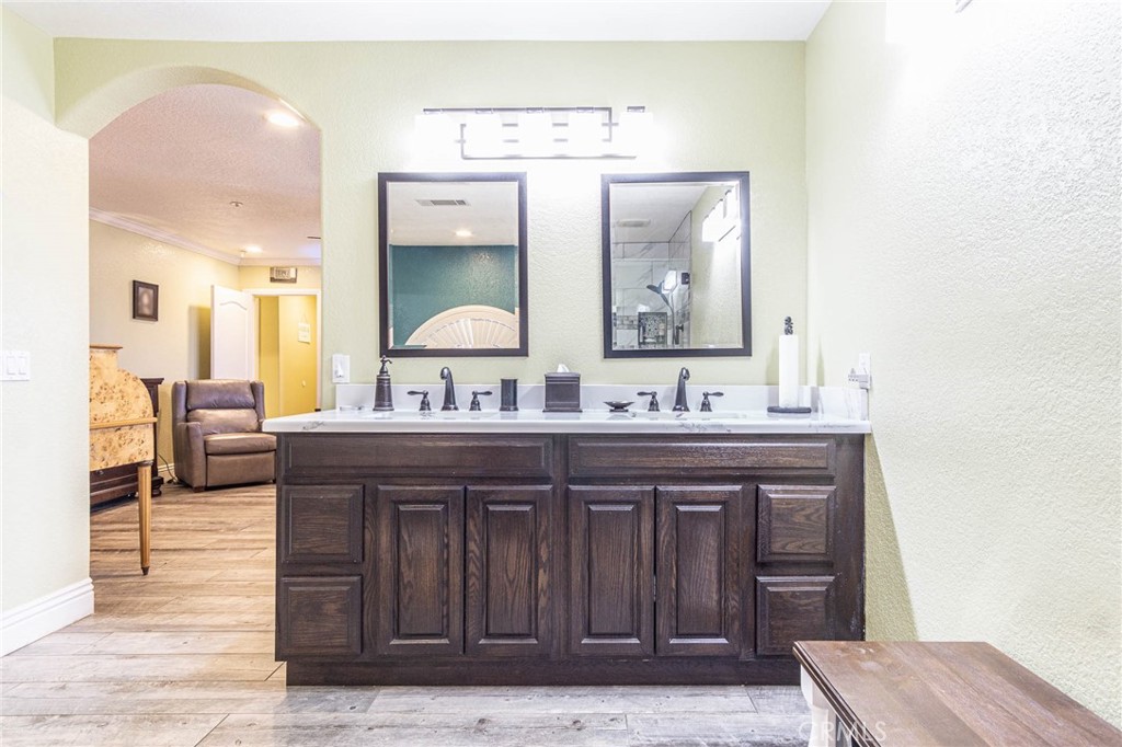 9735 Elsinore Road Oak Hills, CA 92344 - Photo 32 of 64 a spacious bathroom with a granite countertop sink a mirror and a