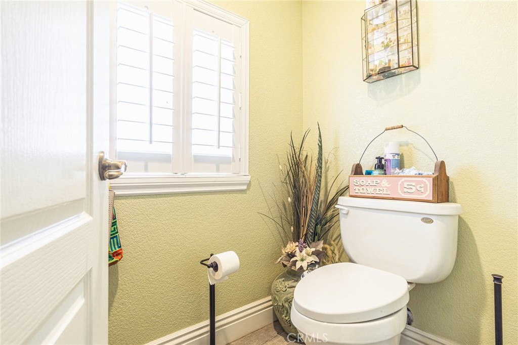9735 Elsinore Road Oak Hills, CA 92344 - Photo 35 of 64 a bathroom with a toilet a sink and a window
