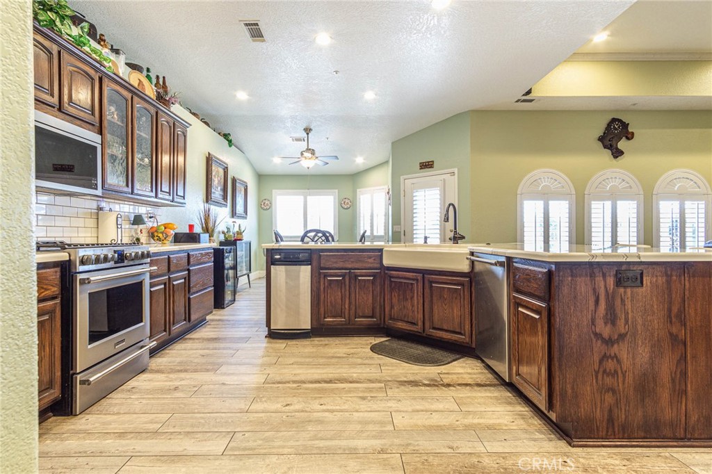 9735 Elsinore Road Oak Hills, CA 92344 - Photo 10 of 64 a kitchen with stainless steel appliances granite countertop a stove a sink dishwasher a oven and a refrigerator