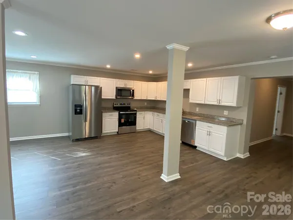 a kitchen with stainless steel appliances a refrigerator and wooden floor