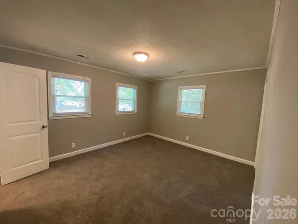an empty room with windows and closet