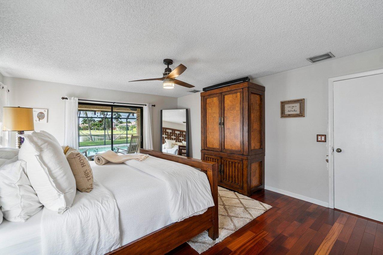 22250 Martella Avenue Boca Raton, FL 33433 - Photo 16 of 45 a bedroom with a bed and wooden floor