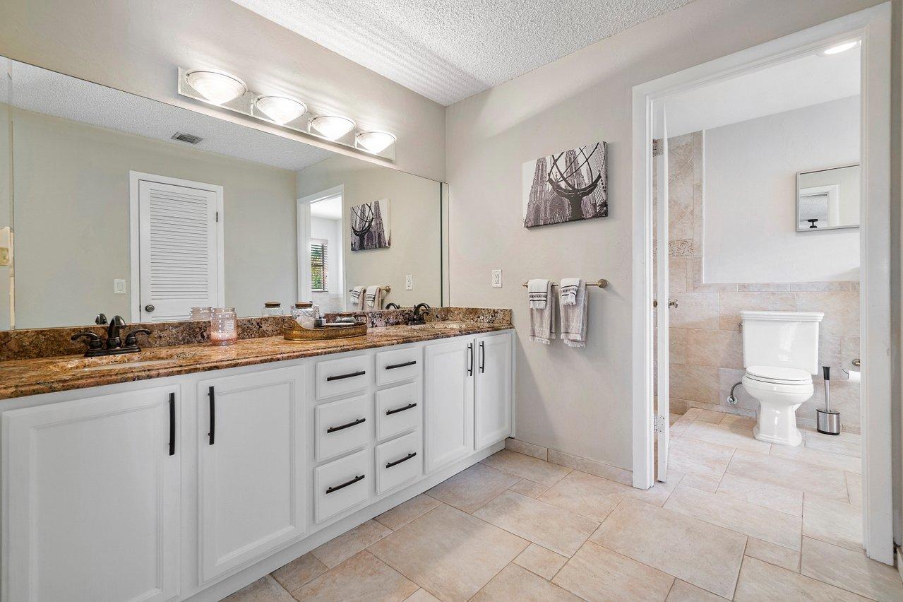22250 Martella Avenue Boca Raton, FL 33433 - Photo 18 of 45 a spacious bathroom with a granite countertop sink and a mirror