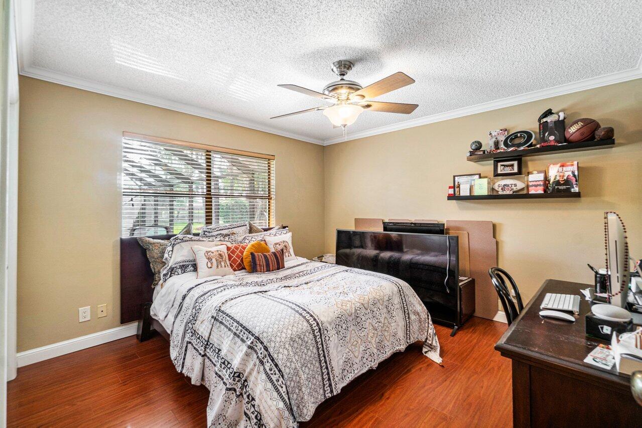 22250 Martella Avenue Boca Raton, FL 33433 - Photo 19 of 45 a bedroom with a bed and wooden floor
