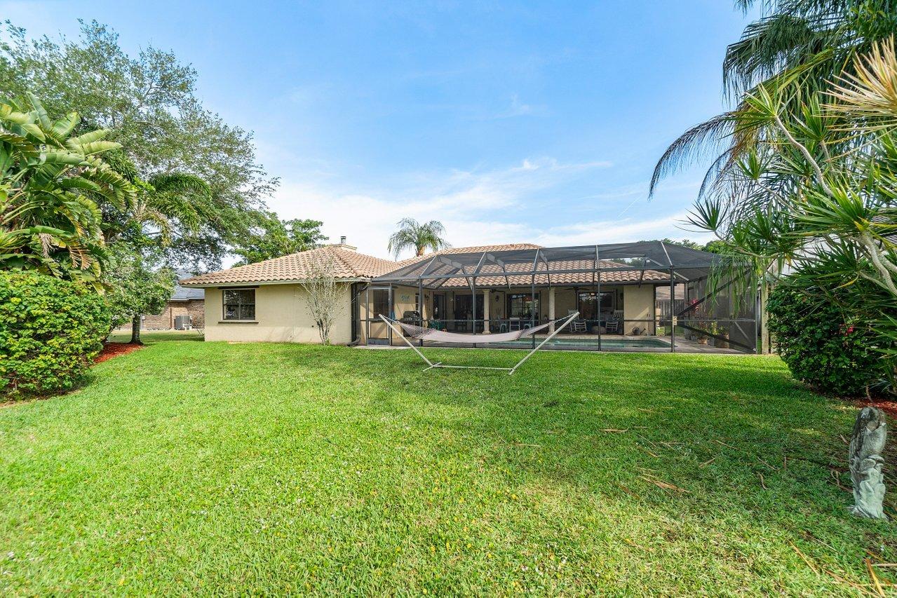 22250 Martella Avenue Boca Raton, FL 33433 - Photo 33 of 45 a front view of a house with a garden
