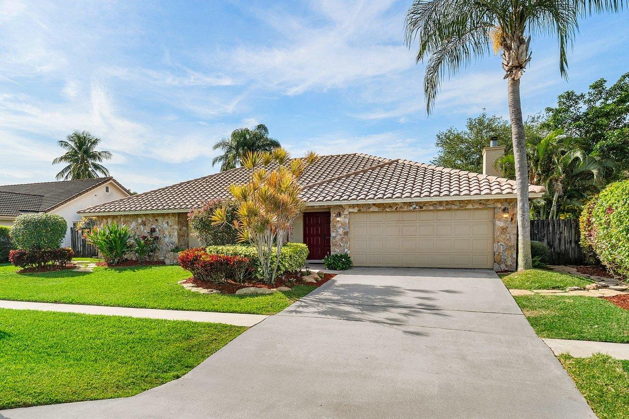 22250 Martella Avenue Boca Raton, FL 33433 - Photo 44 of 45 a front view of a house with a garden and yard