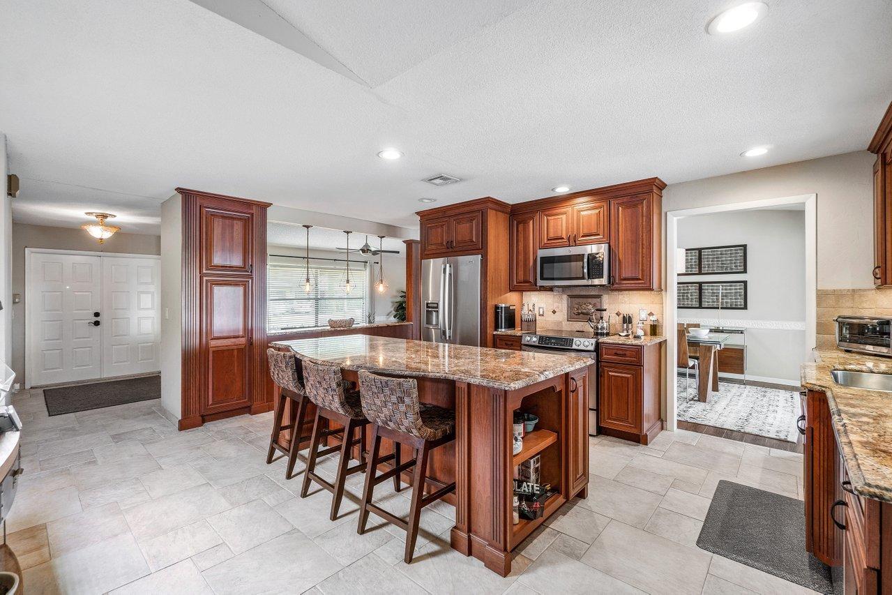 22250 Martella Avenue Boca Raton, FL 33433 - Photo 6 of 45 a large kitchen with a table and chairs in it