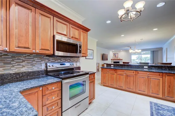 a kitchen with stainless steel appliances granite countertop a stove a sink and a microwave