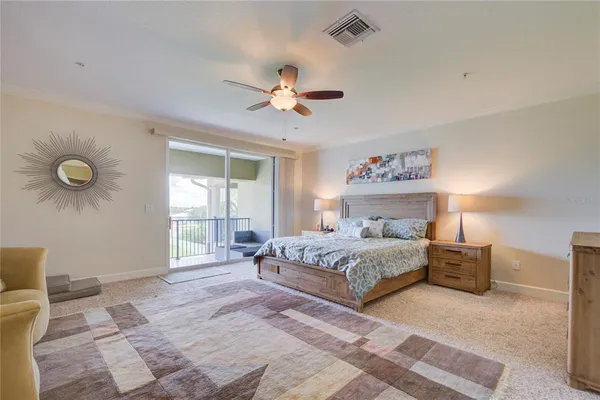 a spacious bedroom with a large bed and a chandelier