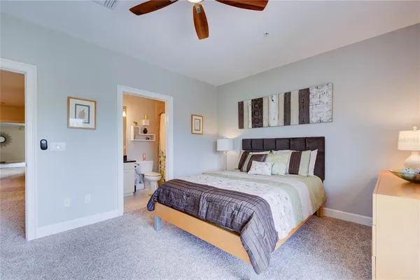 a bedroom with a large bed and a chandelier