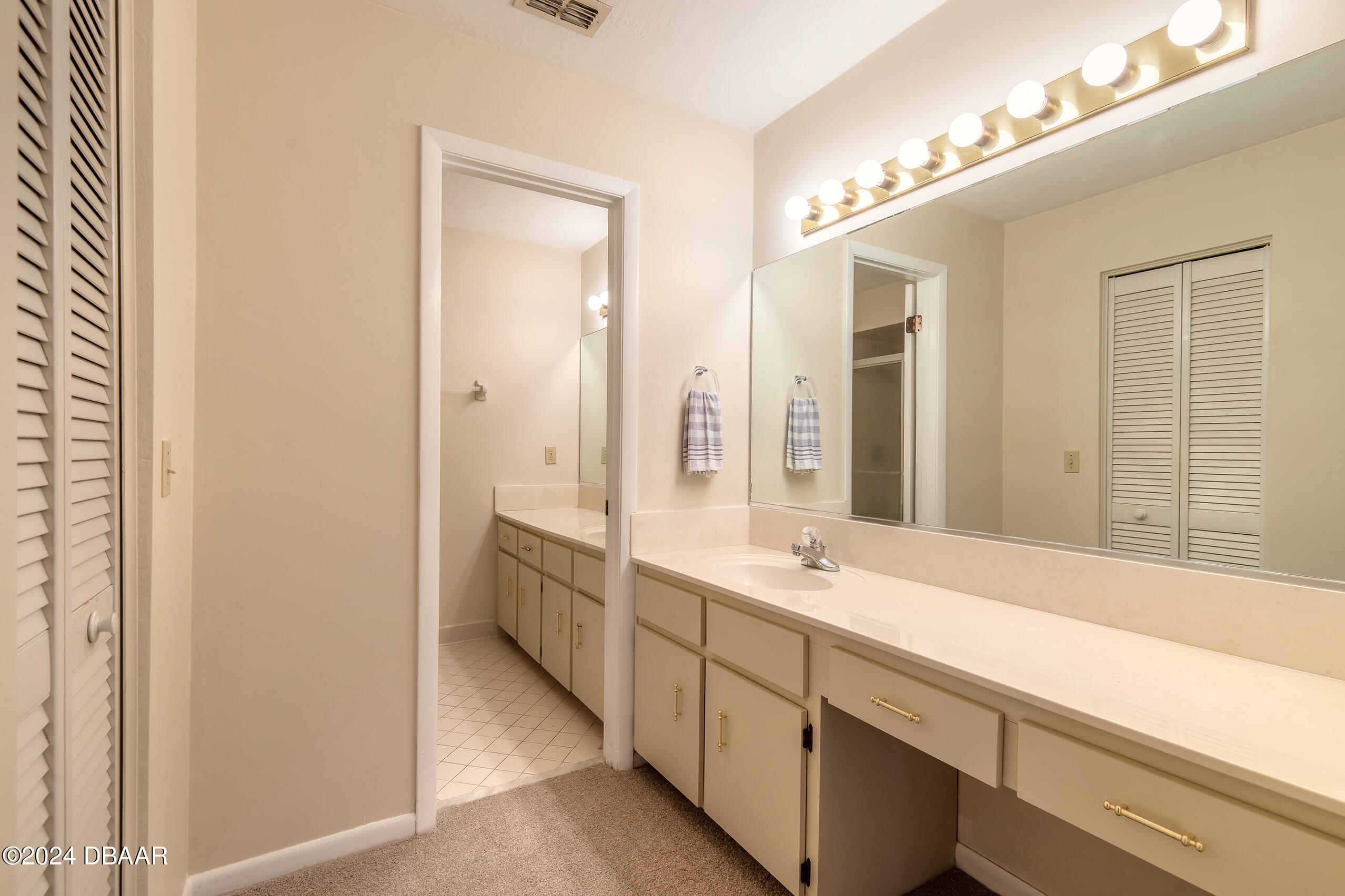 251 Orange Grove Drive, Unit 2 Ormond Beach, FL 32174 - Photo 18 of 32 a spacious bathroom with double vanity and a large mirror