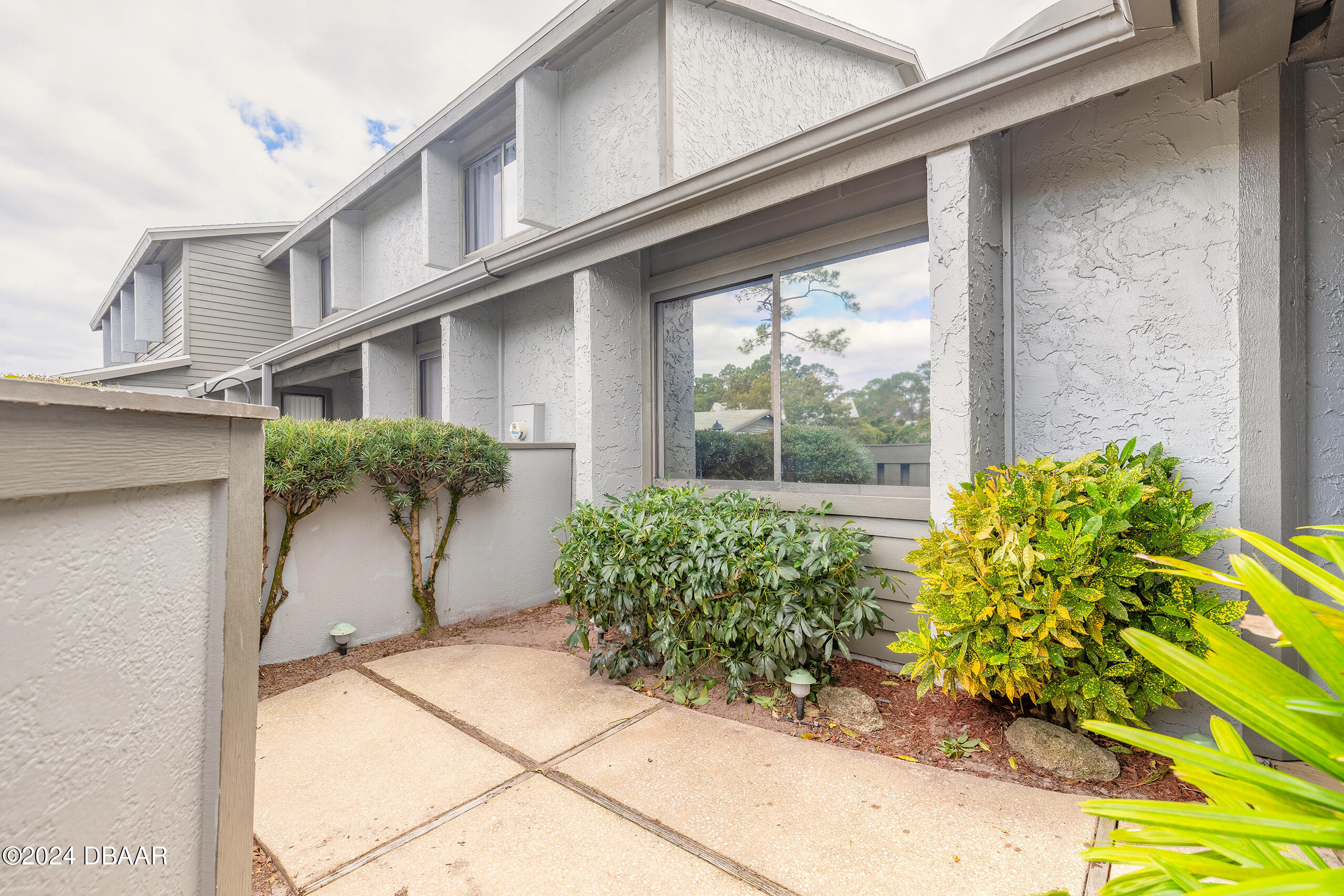 251 Orange Grove Drive, Unit 2 Ormond Beach, FL 32174 - Photo 2 of 32 a front view of a house with garden