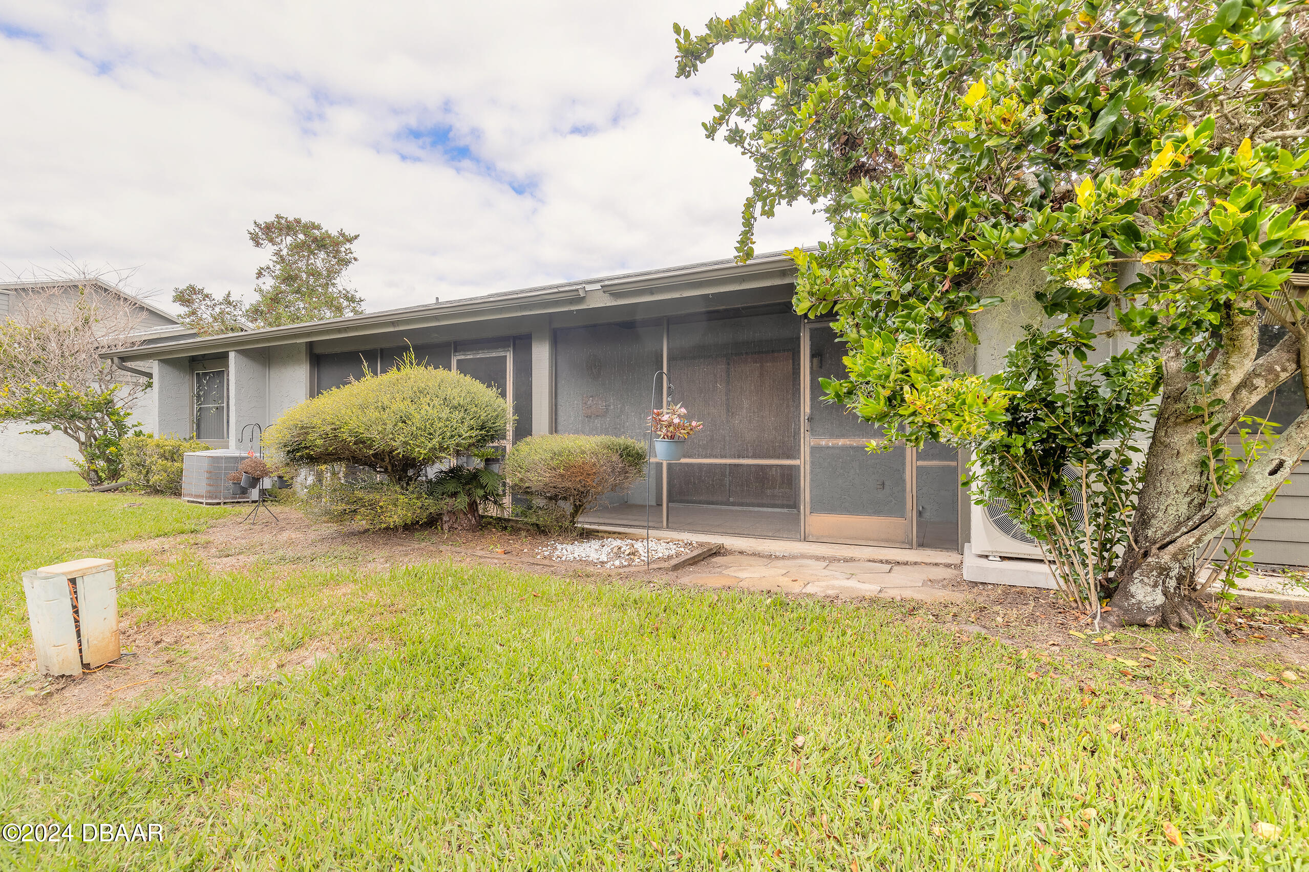 251 Orange Grove Drive, Unit 2 Ormond Beach, FL 32174 - Photo 24 of 32 a front view of house with yard and trees around