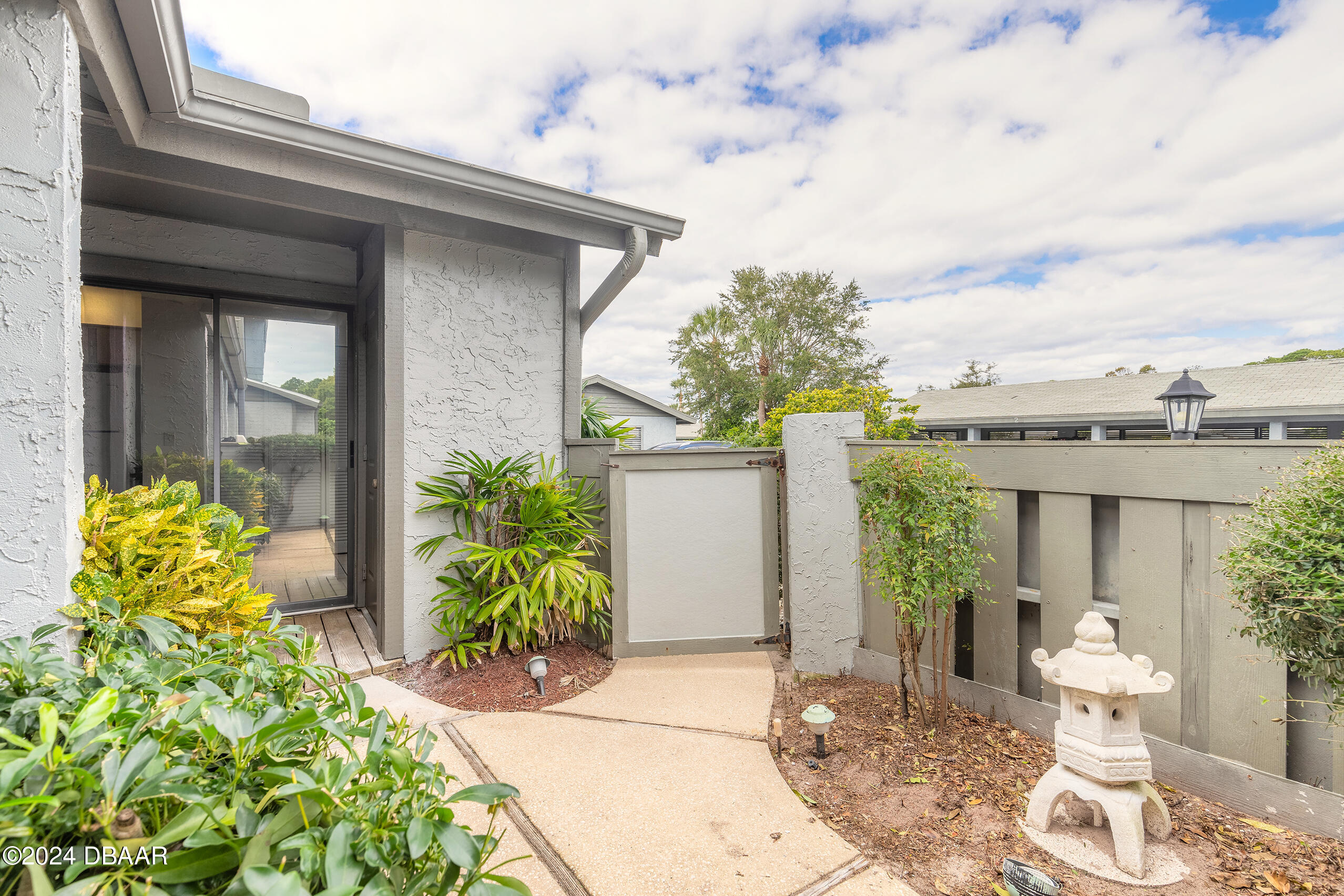 251 Orange Grove Drive, Unit 2 Ormond Beach, FL 32174 - Photo 3 of 32 a front view of a house with garden