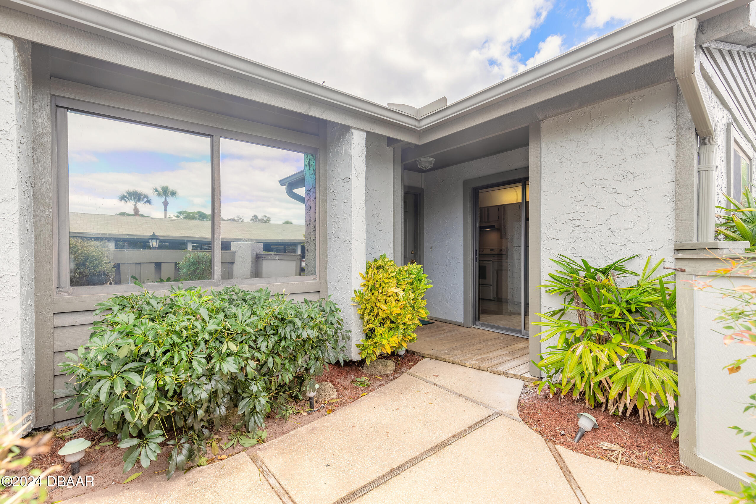 251 Orange Grove Drive, Unit 2 Ormond Beach, FL 32174 - Photo 4 of 32 a view of a bunch of flowers in front of a window