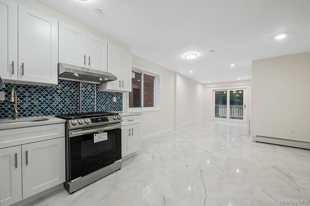 106-05 49th Avenue Queens, NY 11368 - Photo 18 of 39 a kitchen with granite countertop white cabinets and appliances