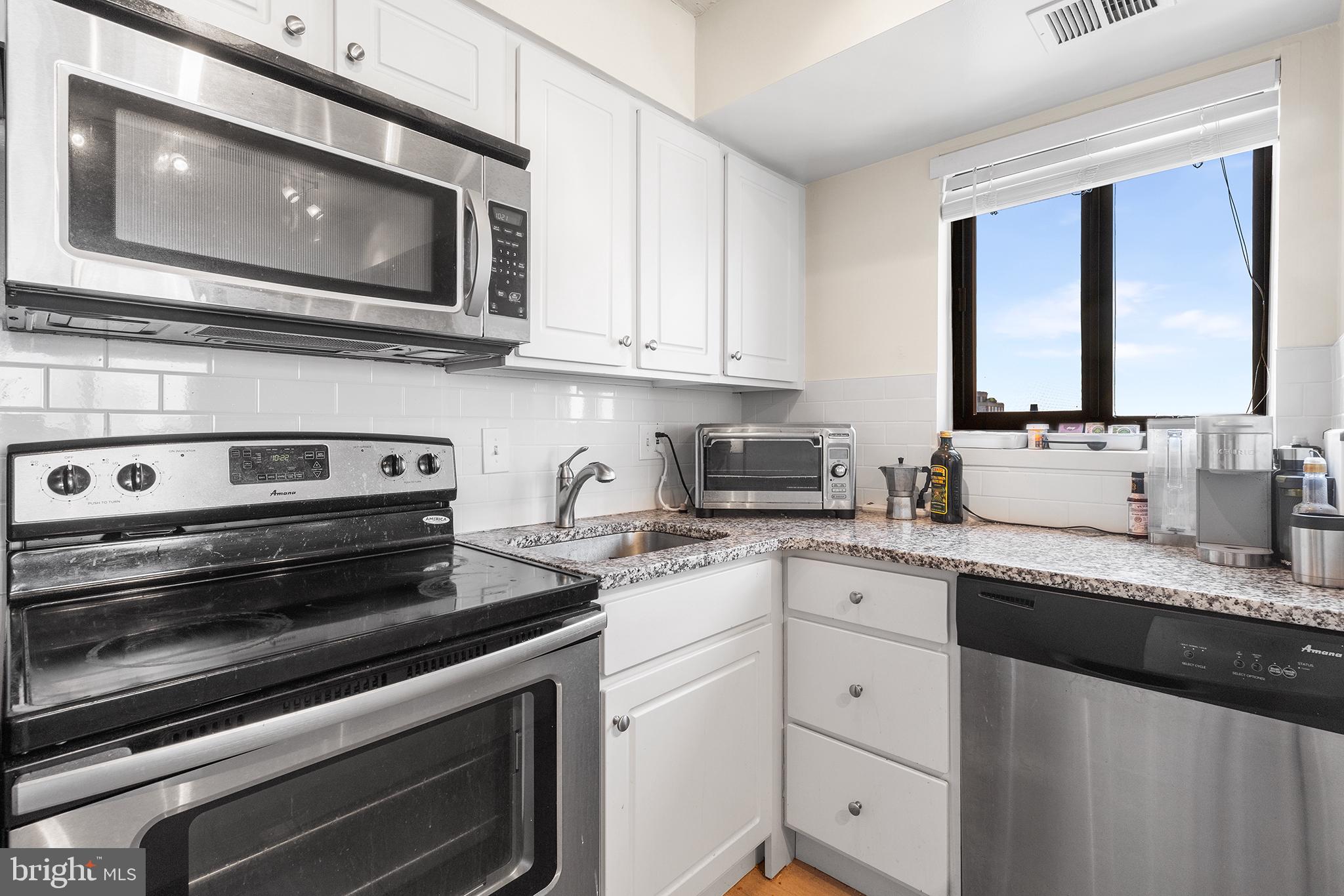 1420 Locust Street, Unit 29J Philadelphia, PA 19102 - Photo 23 of 30 a kitchen with stainless steel appliances granite countertop a stove microwave and sink