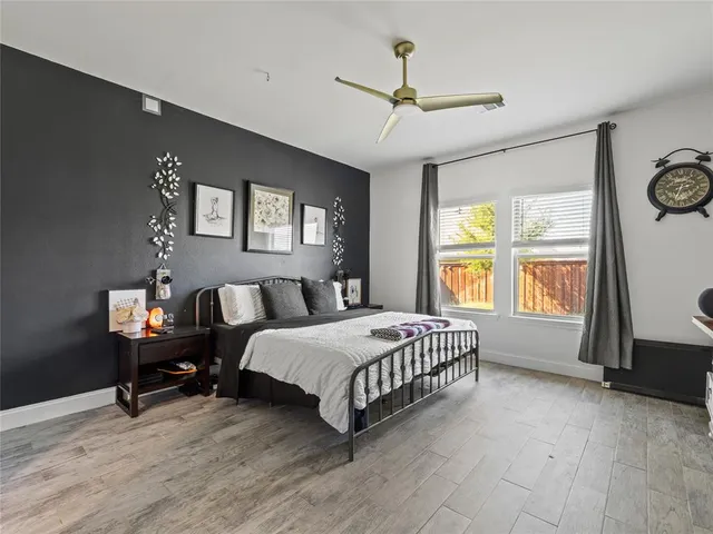 a spacious bedroom with a bed a window and dresser