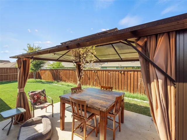 a backyard of a house with table and chairs