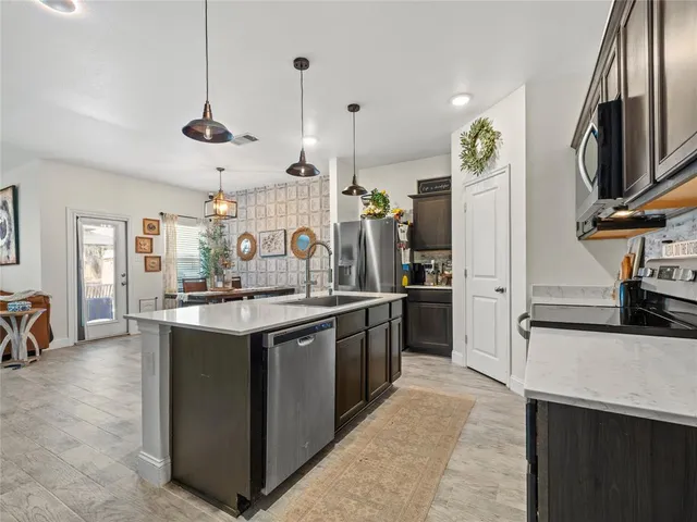 a kitchen with stainless steel appliances granite countertop a sink a stove and a refrigerator