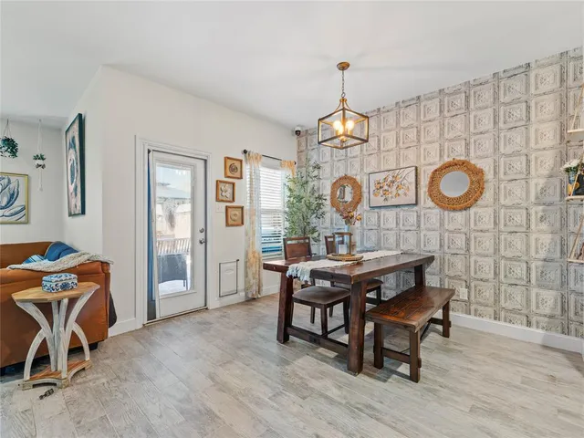 a view of a dining room and livingroom with furniture wooden floor and a clock