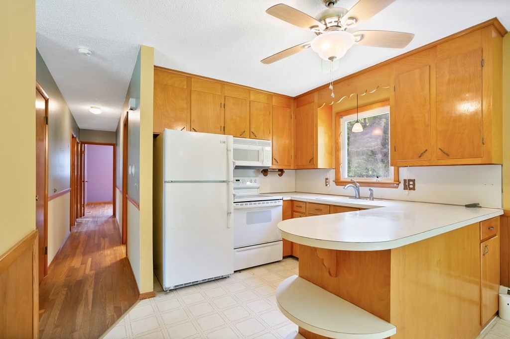 316 Burlingame Road Palmer, MA 01069 - Photo 16 of 31 a kitchen with a sink a refrigerator and white cabinets