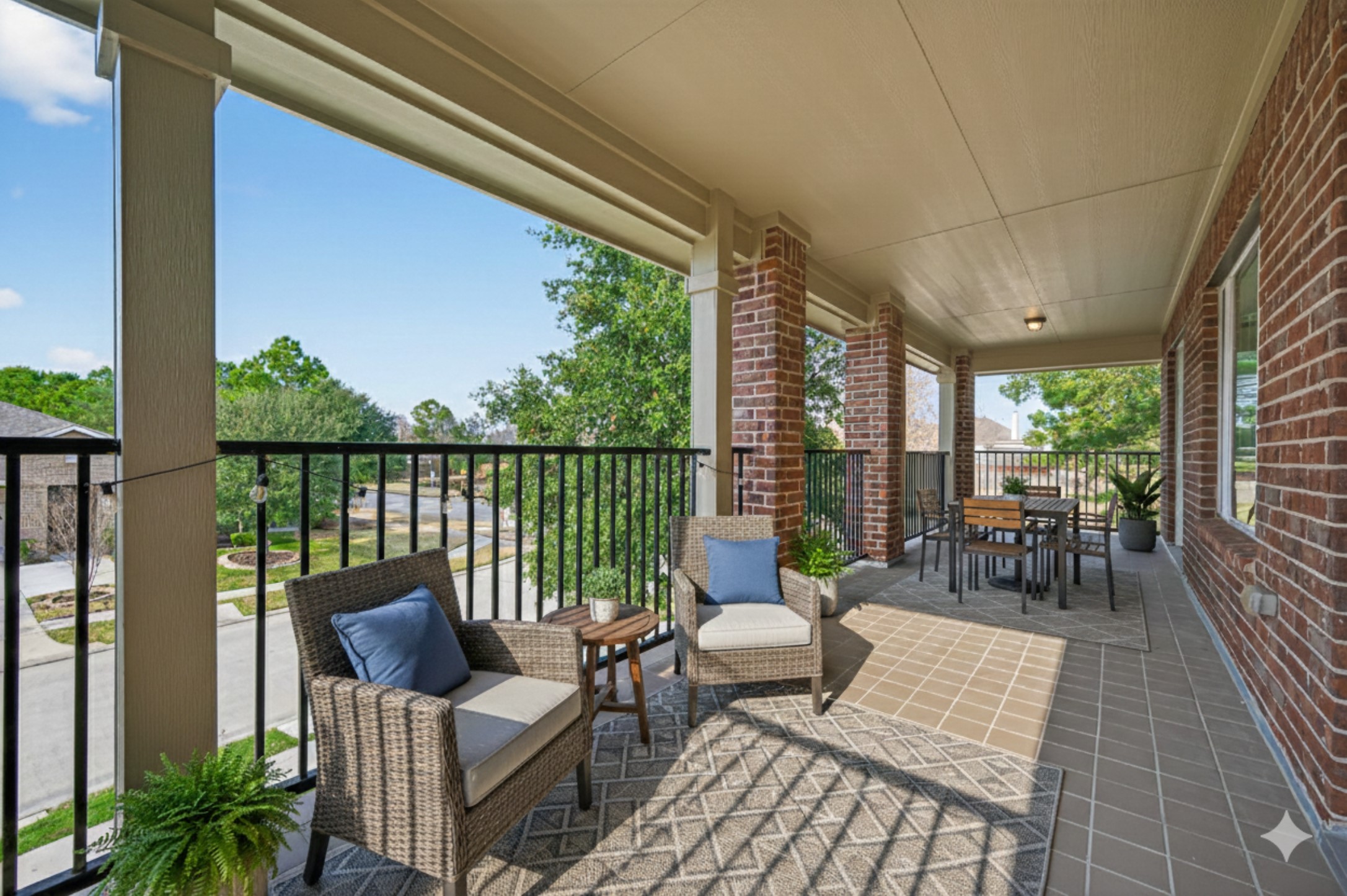 7003 Bristol Memorial Drive Spring, TX 77379 - Photo 6 of 40 Designed for the buyer who values space, privacy, and elevated outdoor living, this oversized covered balcony delivers a true lifestyle upgrade. With generous room for lounge seating, outdoor dining, or a cozy conversation area, it’s the perfect setting for morning coffee, evening unwinding, or hosting guests. Brick columns, tile flooring, and wrought-iron railing add architectural character, while peaceful neighborhood views create a refined, private escape just steps from the upstairs living spaces.