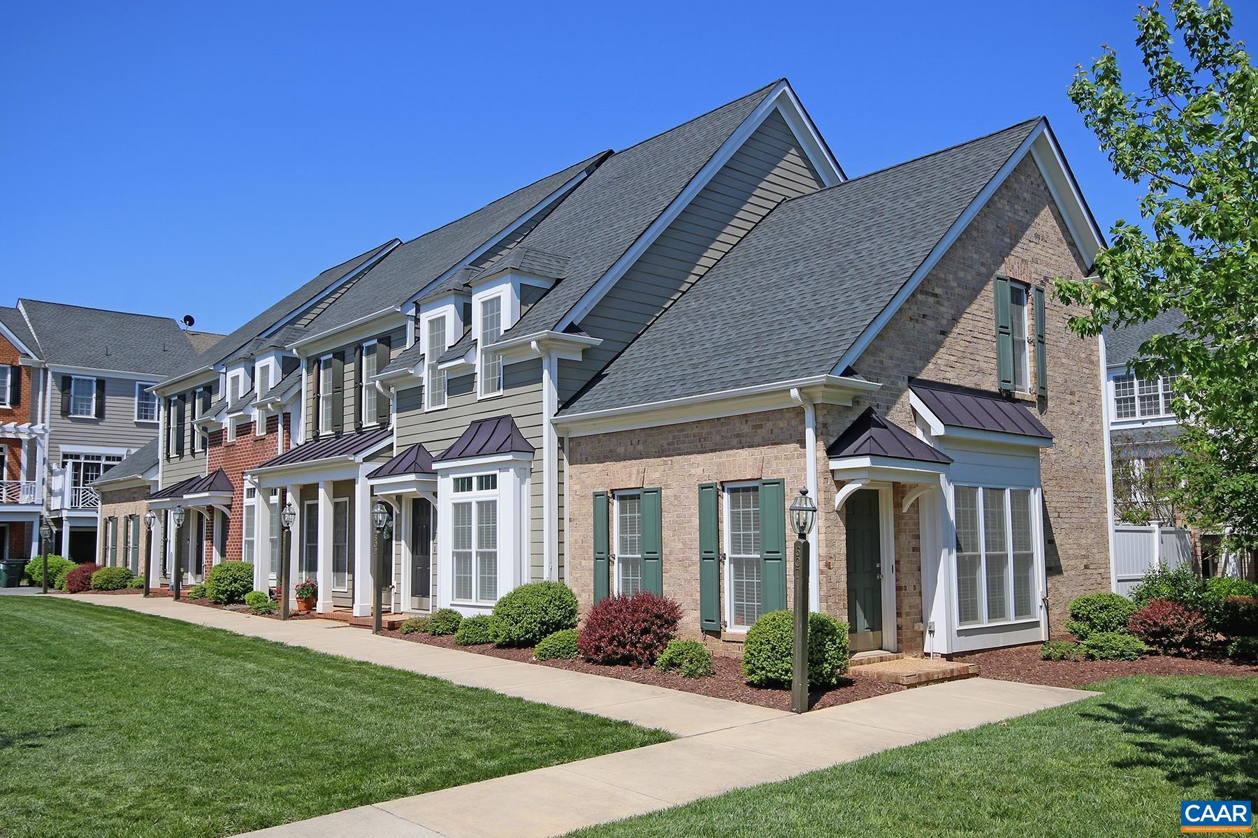 a front view of a house with yard and green space