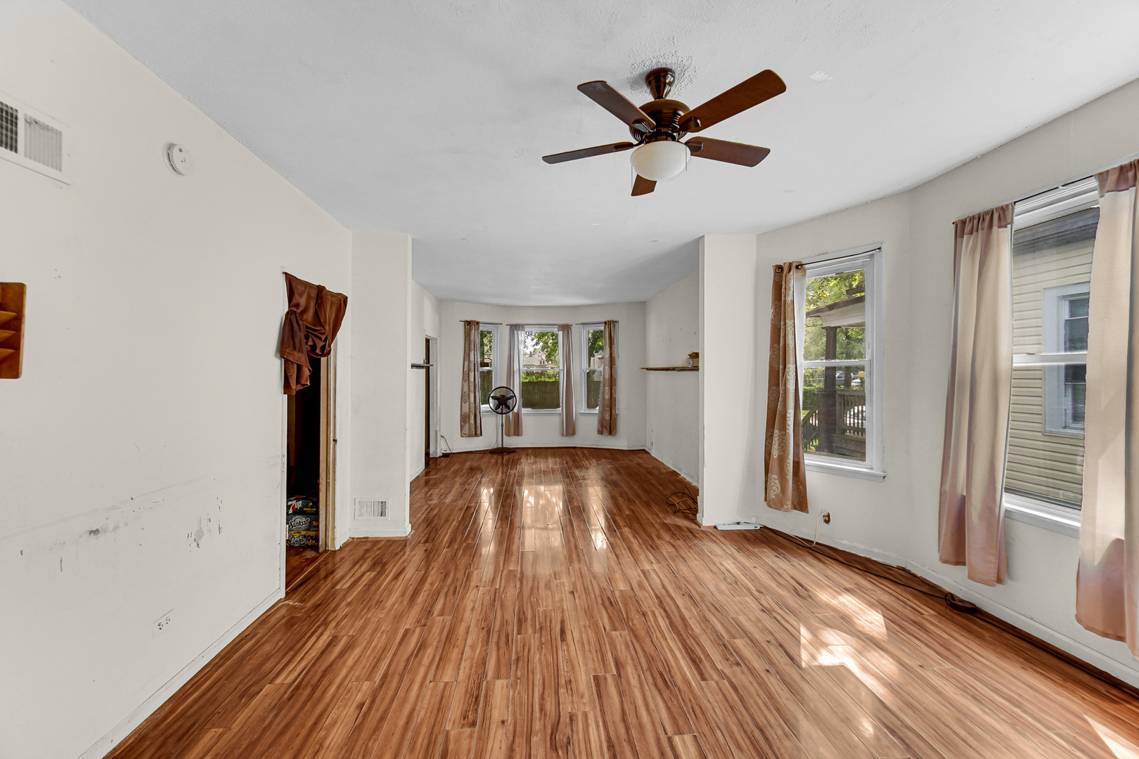 12220 South Normal Avenue Chicago, IL 60628 - Photo 8 of 22 a view of a livingroom with wooden floor and a ceiling fan