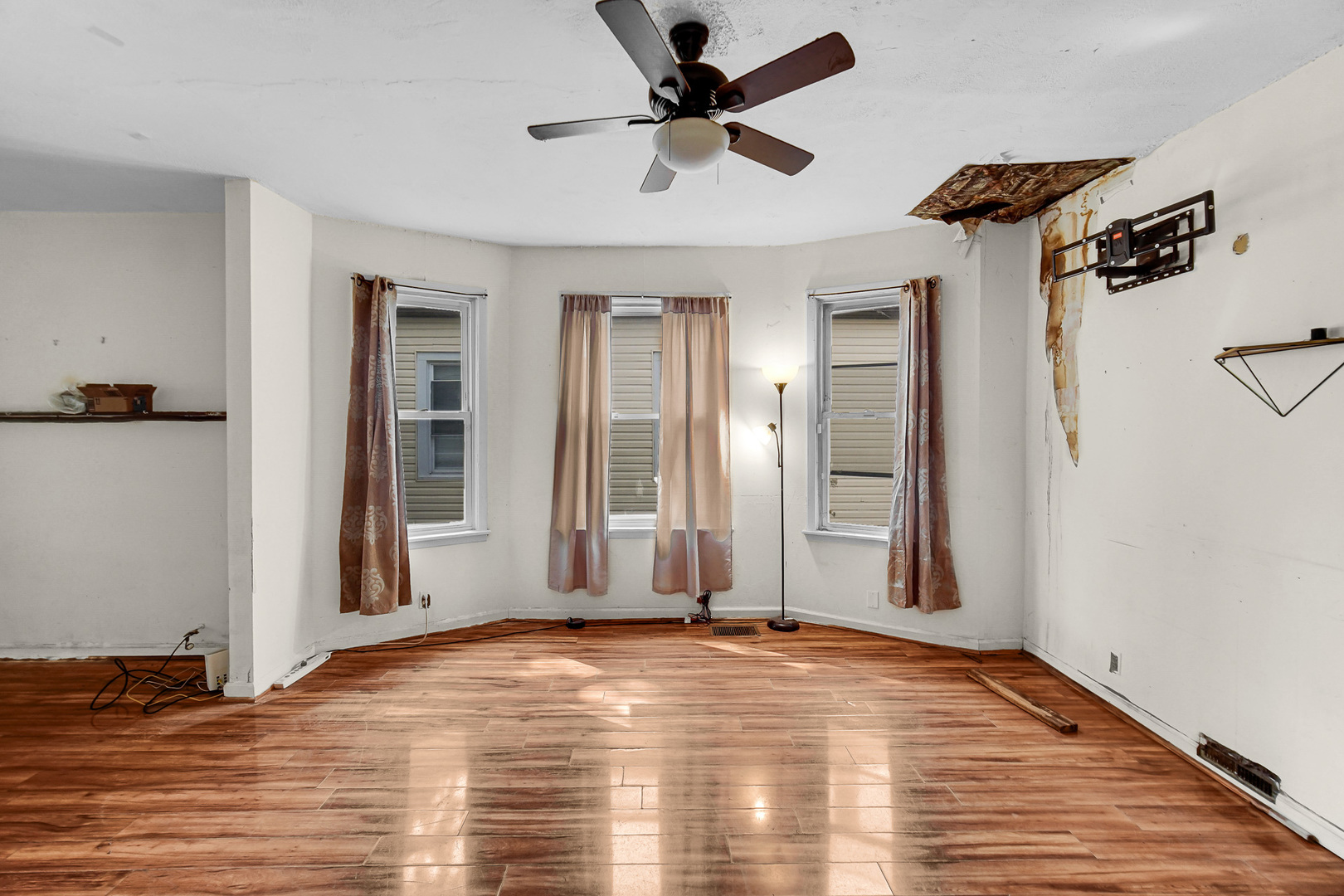 12220 South Normal Avenue Chicago, IL 60628 - Photo 9 of 22 an empty room with wooden floor and a ceiling fan