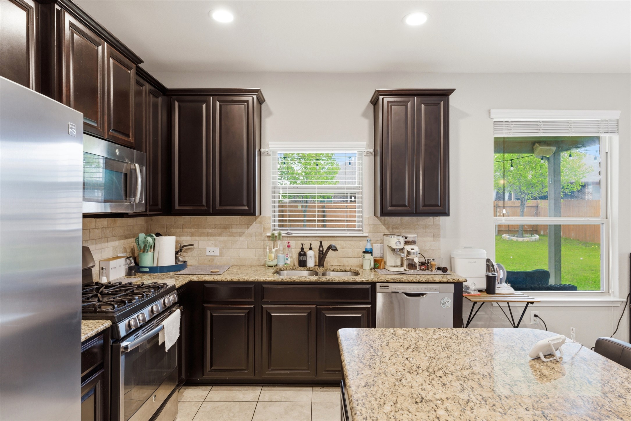 2409 Muzzie Lane Leander, TX 78641 - Photo 12 of 33 a kitchen with stainless steel appliances granite countertop a sink stove and refrigerator