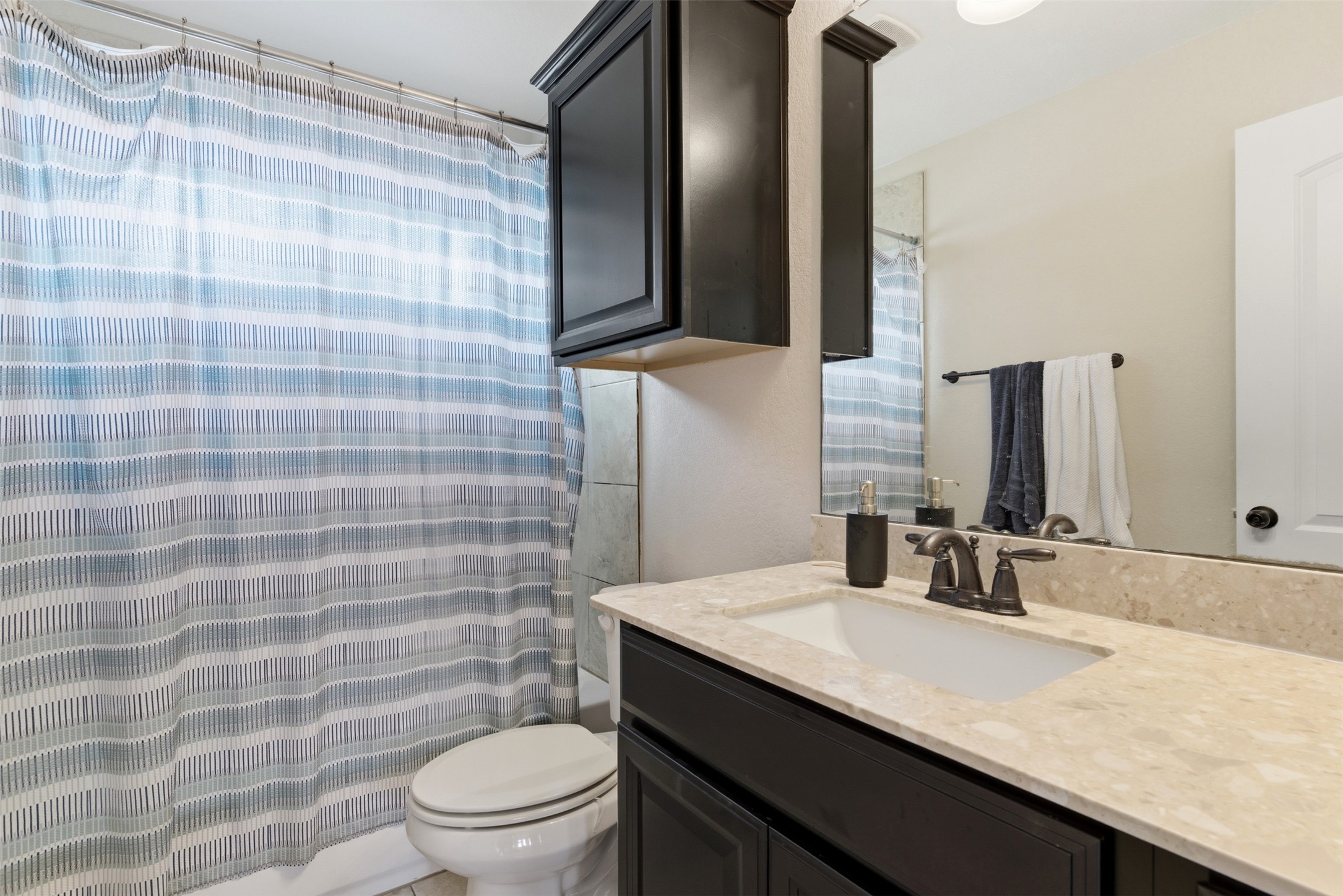 2409 Muzzie Lane Leander, TX 78641 - Photo 18 of 33 a bathroom with a granite countertop sink a toilet and mirror