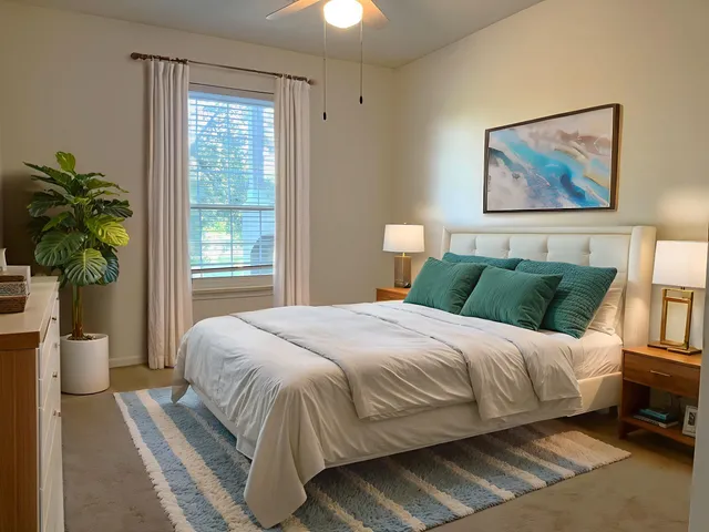 a bedroom with a bed painting on wall and a potted plant