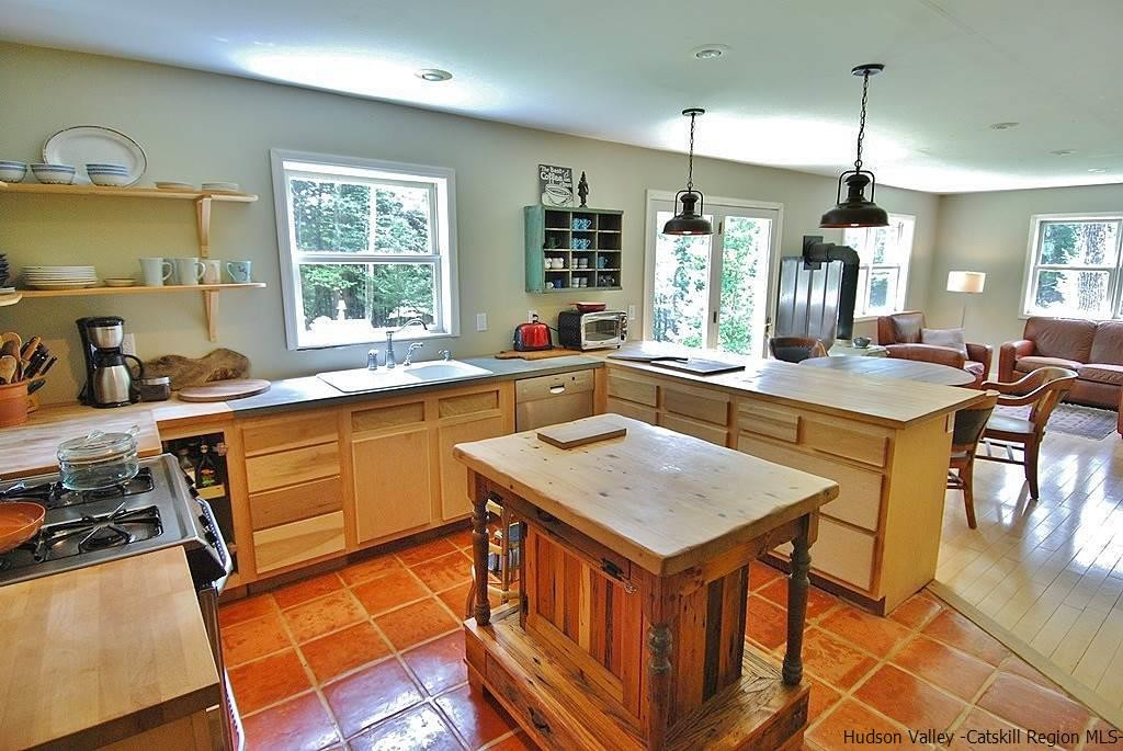 145 Beaverkill Road Kingston, NY 12401 - Photo 3 of 28 a kitchen with a stove a sink a dining table and chairs