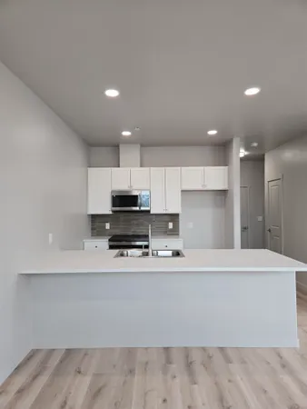 a kitchen with stainless steel appliances granite countertop a sink and a stove top oven