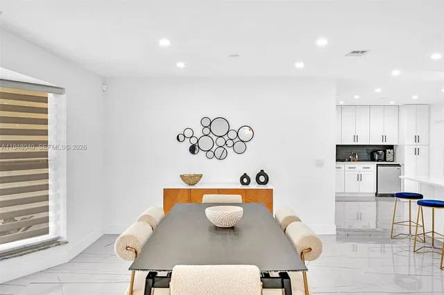 a kitchen with stainless steel appliances kitchen island granite countertop a table and chairs