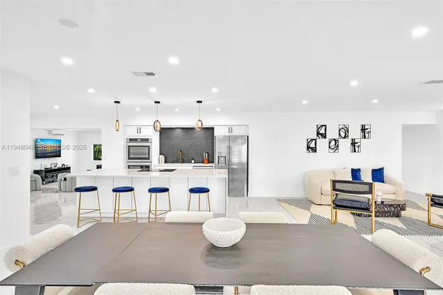 a living room with furniture kitchen view and a flat screen tv