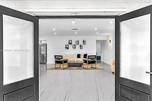 a living room with stainless steel appliances furniture a dining table and kitchen view