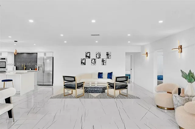 a living room with furniture and kitchen view with wooden floor