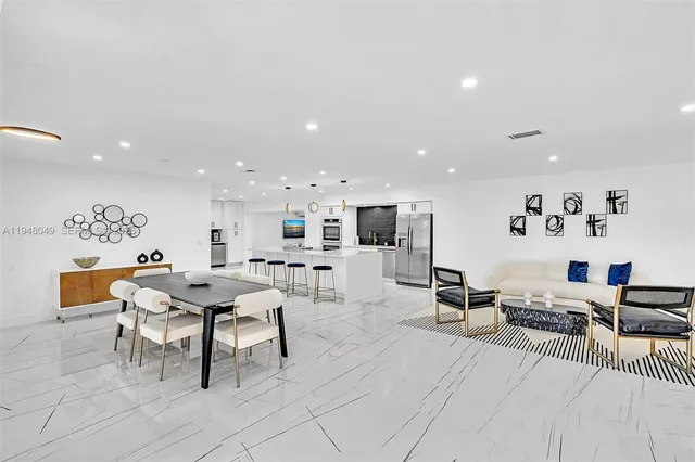 a living room with furniture kitchen view and a wooden floor