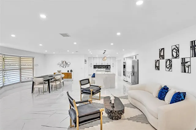 a view of a dining room with furniture a kitchen and chandelier