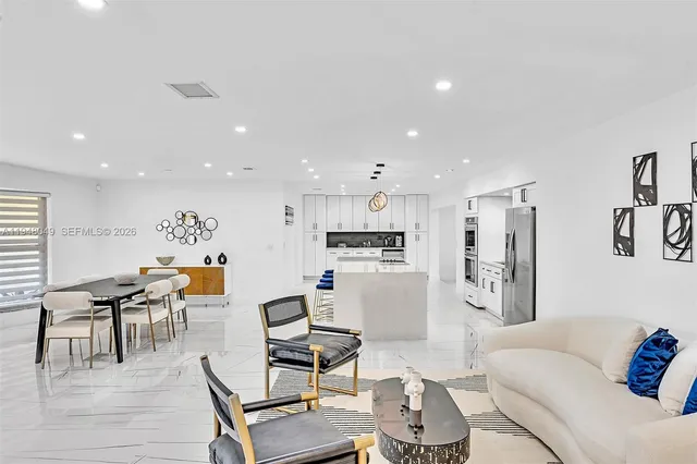 a view of kitchen with kitchen island stainless steel appliances refrigerator stove dining table and chairs