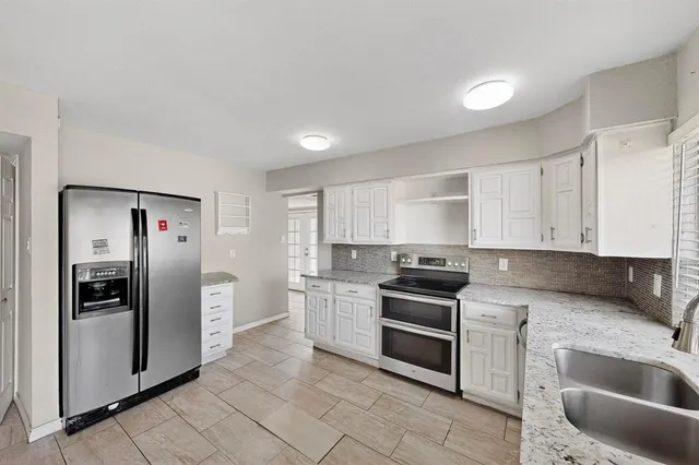 a kitchen with a sink cabinets stainless steel appliances and a window