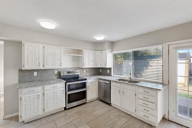 a view of a kitchen with refrigerator and window