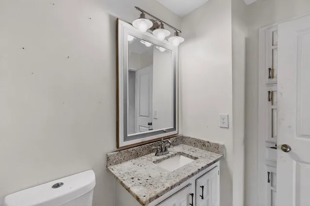 a bathroom with a granite countertop sink and a mirror