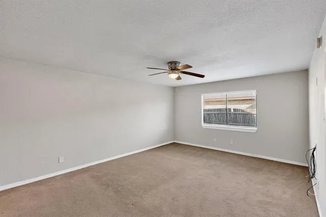 a view of a livingroom with a ceiling fan and window